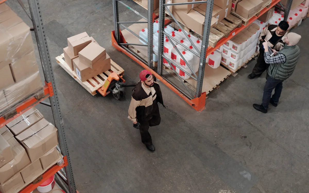 Warehouse team coordinating cross-border logistics among shelves and packed goods