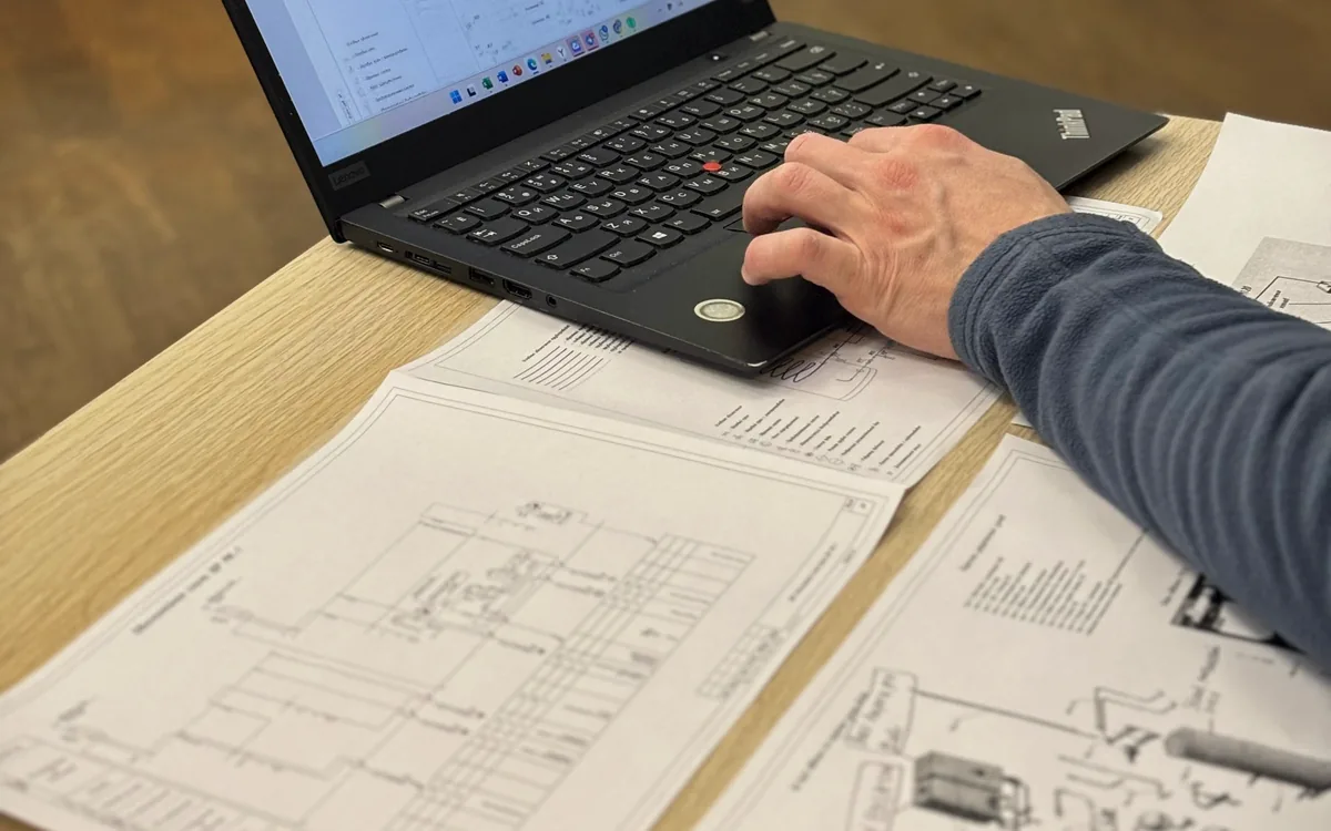 Engineer reviewing technical drawings on a laptop to connect enterprise data with work context