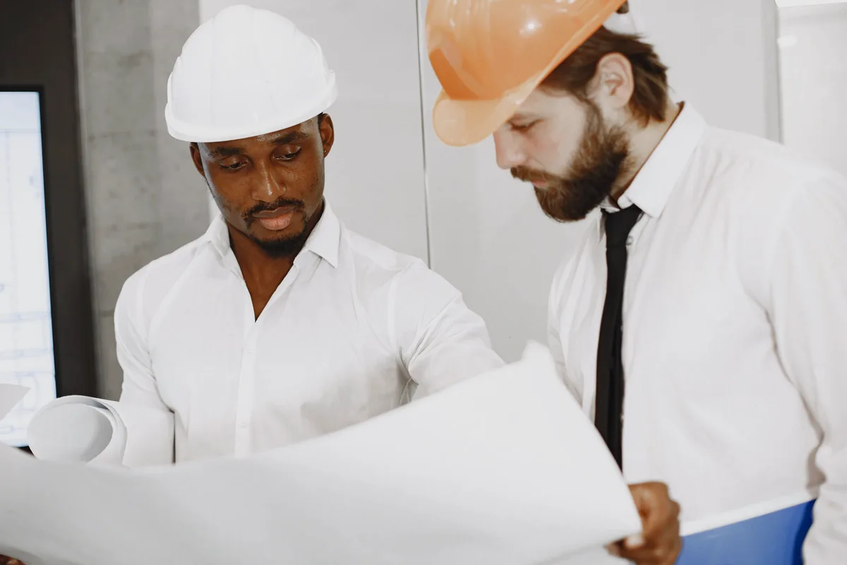 Two engineers reviewing a blueprint together during field discovery